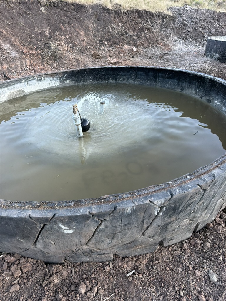 Water flowing into a large tire water trough for livestock on the ranch